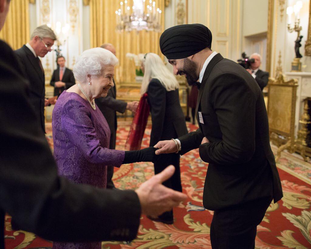 Photo of Sukshinder Shinda exchanges a handshake and a few words with Her Majesty Queen Elizabeth II